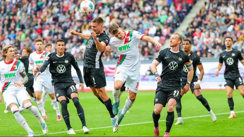 Cầu thủ của Wolfsburg và Augsburg tranh chấp bóng trên sân cỏ